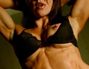 Tina’s sexy in the bedroom in black bra and panties and high boots. Her abs are ripped and vascular, her legs and biceps are strong, and she looks so good you’re going to wish you were right there with her.
