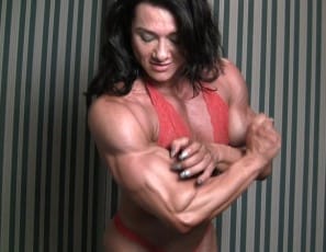 I love it when it's really hard, professional female bodybuilder Alina Popa says, stroking her biceps in the bedroom, and then it pops. You'll love watching her pose and bounce those biceps and her glutes, showing amazing muscle control, and looking at her hard, ripped, vascular legs, calves and abs. It might even make you hard too.