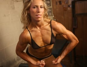Female bodybuilder Denise is posing in the gym in a teeny weeny black bikini that shows just how ripped her abs are and how vascular and muscular her biceps, glutes, and legs are. The bikini's small. But she's big.