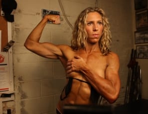 Female bodybuilder Denise is posing in the gym in a teeny weeny black bikini that shows just how ripped her abs are and how vascular and muscular her biceps, glutes, and legs are. The bikini's small. But she's big.