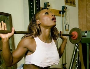 Bodybuilder Mae Kalamus, all in white, gets so excited while she does squats in the gym that she just has to pull her shorts aside. Then she takes them off entirely, showing her gleaming ebony glutes and legs, then squatting while nearly naked. 