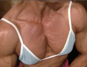 Female bodybuilder Nathalie Falk works her pecs and biceps muscles in the gym and poses to show you how ripped and vascular she is and how good her tattooed abs look. Feels good, she says with a smile. 