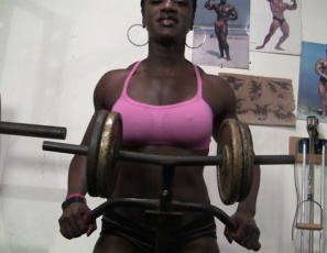 Female bodybuilder Mistress Empress is trash-talking while she works out in the gym and poses, making fun of you and showing off the gleaming ebony muscles of her powerful pecs, massive legs and chocolate biceps. But you'll have to take it – because you know she could crush you.
