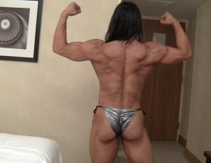 Enjoy a relaxed moment with professional female bodybuilder Tazzie Colomb in the bedroom as she talks about how much her fans mean to her and how she likes her coffee (strong, no surprise) Then she poses half-nude, showing you her massive muscles - her vascular biceps, powerful pecs, big legs and ripped abs.