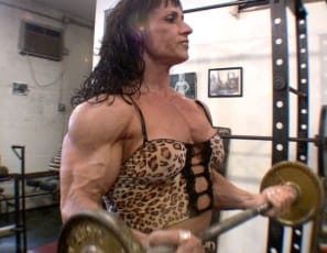Professional bodybuilder Tazzie Colomb, fresh off a competition, works out her biceps in the SheMuscile® gym in this video, getting vascular as she pumps her chest and shoulders and going topless to pose semi-nude and show off her big, muscular legs, glutes and abs. “All right, guys, that was just for you,” she says, breathing hard.
