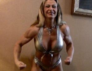 “You’d better be as hard as I am,” bodybuilder Gina Jones says with a big smile as she poses in the bedroom, showing her great muscle control, her beautiful back and biceps and her very sexy pecs, abs, glutes and legs, touching her hard nipples and teasing you with her tiny panties. Are you?