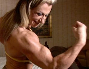 The phone starts ringing just as bodybuilder Gina Jones is flexing her big biceps and posing for you in the bedroom, showing off her sexy pecs, tight, vascular abs, and powerful legs and glutes. “Somebody better get  the phone,” she laughs. “Oh, wait. Your hands are too busy.” Come on, pick it up. It’s for you.
